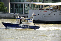 Police Boat on the Thames River, passing HMS Belfast